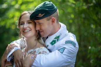 Bräutigam, der die Braut von hinten an einer Militärhochzeit in Ungarn umarmt