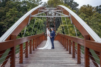 Hochzeitspaar steht auf einer Holzbrücke in Ungarn