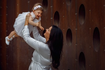 Anya a gyermekét a levegőbe feldobja a Várkert Bazárban fotózás alkalmával
