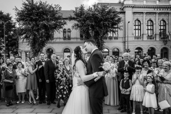 A vőlegény megcsókolja a menyasszonyt a násznép előtt