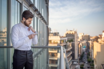 Groom buttoning his shirt on a hotel balcony in Beirut