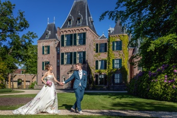 Holland kastélynál sétáló esküvői pár