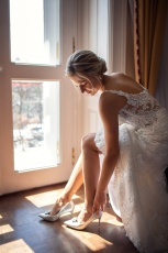 A menyasszony felveszi a cipőjét - Kristály Imperial Hotel esküvői fotózás, Tata