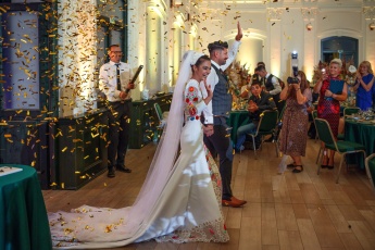 Bride and groom enters the venue with flower petals