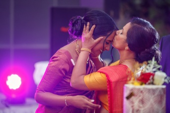 Indian mother kisses the bride on the forehead during wedding