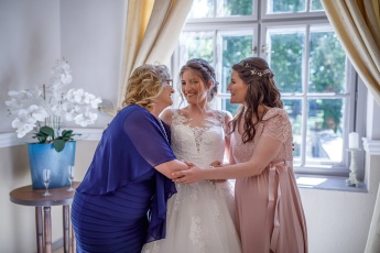 Bride,  mother and sister hugging each other