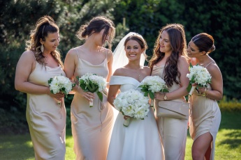 Bride and bridesmaids smiling and looking at each other